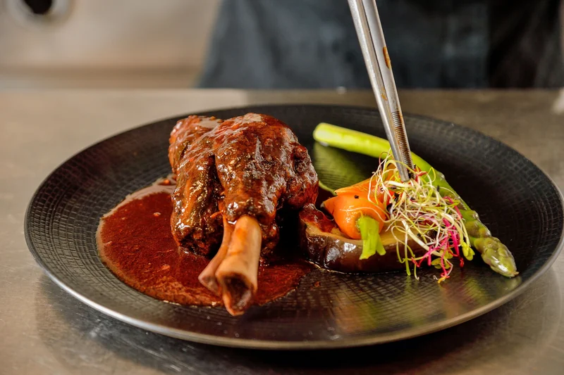 Une assiette de viande en sauce et de légumes colorés